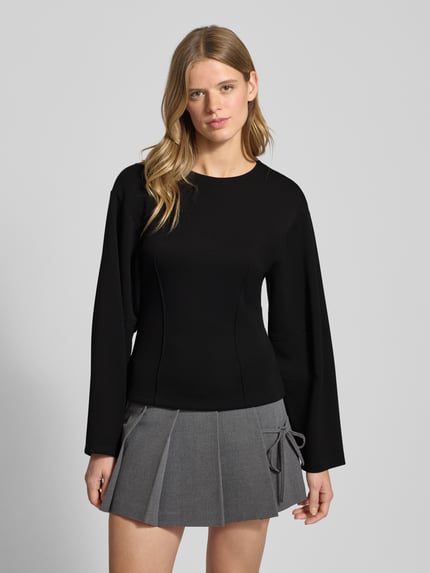 Frauenmodel trägt Shaped Fit Langarmshirt mit Viskose-Anteil Modell 'TOC' von Only, unifarben schwarz, Kimonoärmel, Nahaufnahme Oberkörper.