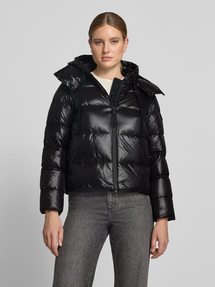 Frauenmodel trägt schwarze Steppjacke mit Kapuze und Eingrifftaschen Modell 'KENID' von Peuterey, glänzende Oberfläche, Ganzkörperansicht von vorne. Rückenlänge 61 cm, Schulterbreite 41 cm, Brustweite 48 cm, Ärmellänge 60 cm.