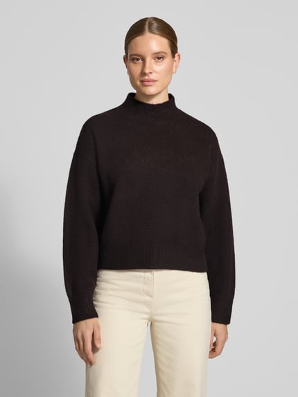 Frauenmodel trägt Turtleneck-Pullover mit Woll-Anteil und Rundhalsausschnitt von Neo Noir in Dunkelbraun, Struktur-Strick, Ganzkörperansicht von vorne. Modell Paulina, gerader Schnitt, gerippte Abschlüsse, Material-Mix.