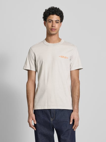 Mannenmodel draagt Regular Fit T-Shirt mit Logo-Print van Replay in beige katoen met ronde hals, oranje logo, regular fit, vooraanzicht van het hele lichaam.