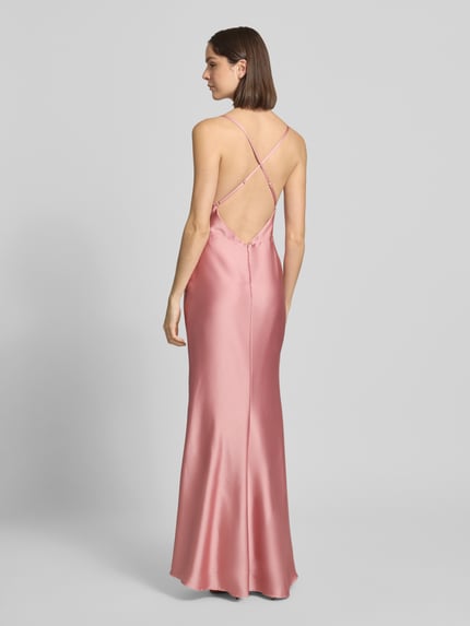 Frauenmodel trägt Slim Fit Abendkleid mit Rückenausschnitt von Laona aus rosafarbenem Satin, verstellbare Spaghettiträger, Ganzkörperansicht Rückansicht.