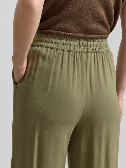 Frauenmodel trägt Regular Fit Weite Hose aus Viskose-Leinen-Mix Modell 'VIVA-GULIA' von Selected Femme, Optik: Unifarben, Flammgarn, Nahaufnahme Rückansicht.