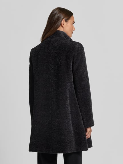Frauenmodel trägt Mantel aus Schurwolle-Alpaka-Mix mit Stehkragen von ICONS Cinzia Rocca, dunkler Ton, weiche Textur, Ganzkörperansicht Rückansicht.