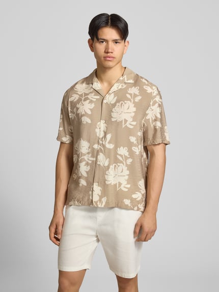 Männermodel trägt Regular Fit Freizeithemd aus Viskose-Mix von REVIEW, beige mit Blumenmuster, Knopfleiste, Reverskragen, 1/2-Arm, Ganzkörperansicht von vorne. Rückenlänge bei Größe M: 74 cm, Schulterbreite: 54 cm, Ärmellänge: 30 cm.