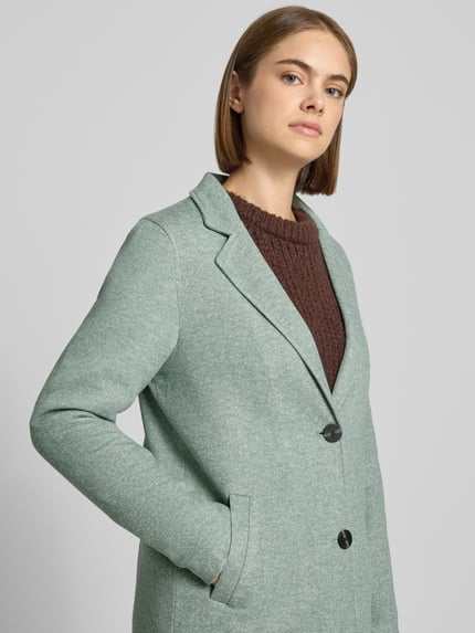 Kobieta modelka nosi Regular Fit Mantel mit Baumwoll-Anteil Modell 'SEDONA' od ONLY w kolorze pastelowo zielonym, tekstura gładka, Nahaufnahme górnej części ciała