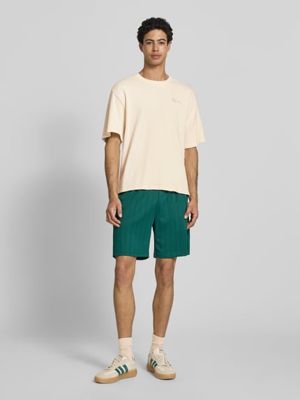 Männermodel trägt Oversized T-Shirt mit Logo-Stitching von KARL KANI aus Reine Baumwolle, Oversized-Fit, Rundhalsausschnitt, Herren T-Shirt, Vorderansicht, Rückenlänge bei Größe M 65 cm.