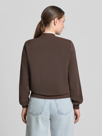 Vrouwenmodel draagt Regular fit blouson met ritssluitingdetail van VERO MODA in bruin, lichte jeans, Ganzkörperansicht Rückansicht.