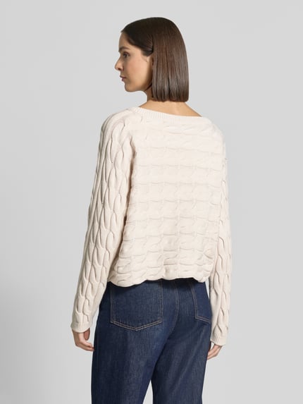 Vrouwenmodel draagt Relaxed Fit Strickpullover aus Baumwoll-Mix met kabelpatroon van Oui in beige, katoenmix, boothals, ruglengte maat 36: 48 cm, mouwlengte maat 36: 60 cm, Ganzkörperansicht Rückansicht.