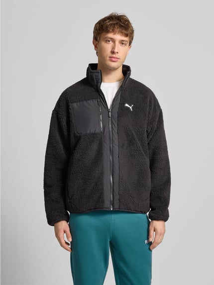 Männermodel trägt Sherpa Jacket mit Reißverschluss von PUMA PERFORMANCE in Schwarz mit Label-Print, Lockerer-Schnitt, Reißverschlusstaschen, Stehkragen, Ganzkörperansicht von vorne. Rückenlänge 68 cm, Schulterbreite 60 cm, Brustweite 63 cm, Ärmellänge 59 cm.