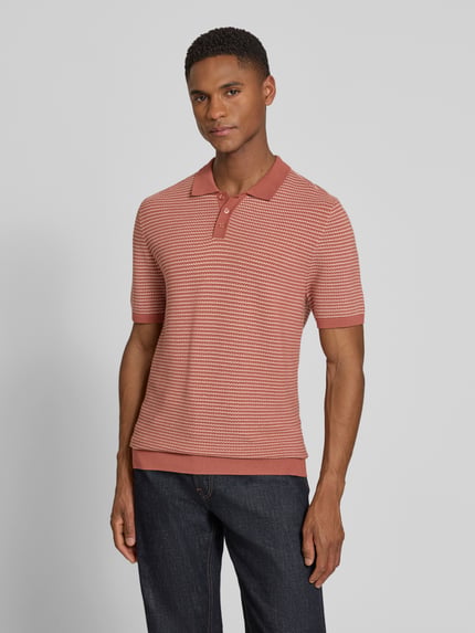 Männermodel trägt Slim Fit Strick-Poloshirt in Two-Tone-Machart Modell 'Triton' von Drykorn, dezente Rot- und Cremetöne, Nahaufnahme Oberkörper, reine Baumwolle, Strukturstrick, Herren Poloshirt