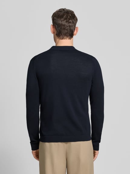 Männermodel trägt dunkelblaue Strickjacke mit Polokragen Modell 'CAMICIA IN MAGLIA' von MARKUP aus reiner Baumwolle, Slim Fit, Knopfleiste, Ganzkörperansicht Rückansicht.