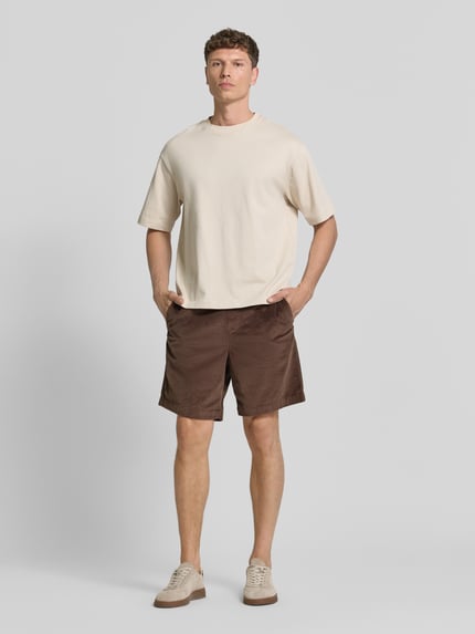 Männermodel trägt Regular Fit Sweatshorts aus Baumwoll-Mix Modell 'JACE' von SELECTED HOMME in Braun mit Cordstruktur, unifarben, Ganzkörperansicht von vorne.