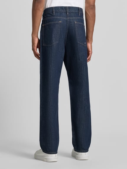 Männermodel trägt Wide Fit Jeans aus reiner Baumwolle von Paul Smith in Dunkelblau mit 5-Pocket-Design, Ganzkörperansicht Rückansicht.