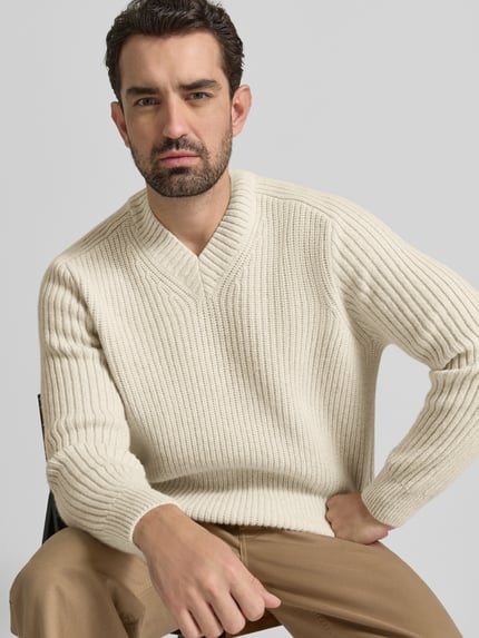 Männermodel trägt Shaped Fit Strickpullover aus Schurwoll-Mix Modell 'KARINET' von BOSS Orange, Optik: Unifarben, Zopfmuster, Nahaufnahme Oberkörper.