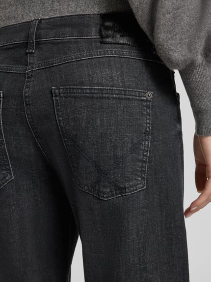 Frauenmodel trägt Regular Fit Straight Fit Jeans mit Bundfalte Modell 'Gina Straight' von MAC, dunkle Denimoptik, Detailaufnahme der Gesäßtaschen, 5-Pocket-Design, dezente Bundfalte, Nahaufnahme Rückansicht.