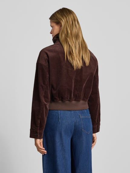 Frauenmodel trägt Regular Fit Blouson aus Baumwoll-Mix von Marc O'Polo DENIM in Braun, Cord-Struktur, kombiniert mit blauer Jeans, Ganzkörperansicht Rückansicht.
