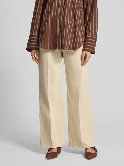 Frauenmodel trägt Wide Leg Jeans aus Baumwoll-Mix von s.Oliver RED LABEL, efekt: jednolity kolor, krój wide fit, wysoki stan, aplikacja z logo na guziku, szlufki na pasek, zapięcie na guzik i ukryty zamek błyskawiczny, 5 kieszeni, wykończenie materiału: denim, mieszanka bawełny, Ganzkörperansicht von vorne.