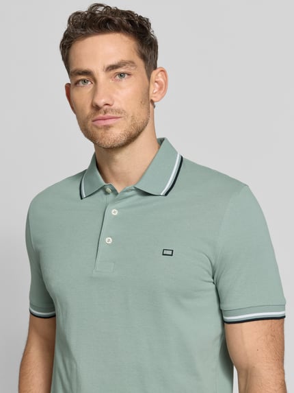 Männermodel trägt Regular Fit poloshirt mit contraststrepen von Christian Berg Men aus puur katoen, knoopsluiting, maat M ruglengte 71 cm, nahaufnahme oberkörper.