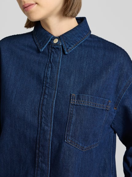 Frauenmodel trägt Figurumspielendes Jeanskleid aus Baumwoll-Viskose-Mix von Marc O'Polo, dunkelblauer Denim, Brusttasche, Nahaufnahme Oberkörper.