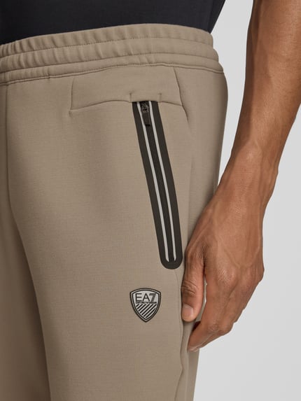 Männermodel trägt Bermudas mit Reißverschlusstaschen von EA7 Emporio Armani, Material-Mix mit Viskose-Anteil, Regular-Fit, Nahaufnahme Oberkörper.