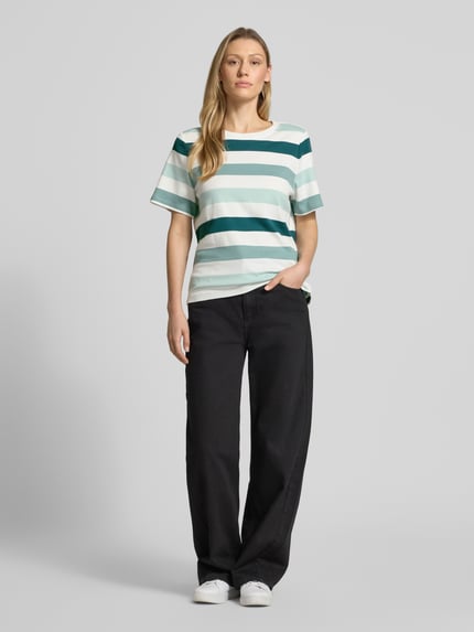 Frauenmodel trägt Relaxed Fit T-Shirt aus reiner Baumwolle von Tom Tailor, Optik: Unifarben, Motiv-Print, Rundhals, Kurzarm, Ganzkörperansicht von vorne.