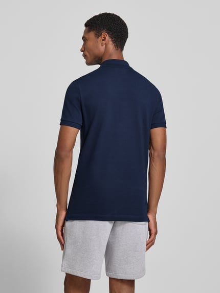 Męski model nosi Slim Fit Poloshirt aus reiner Baumwolle von Lacoste, ciemnogranatowy, gładka faktura, Ganzkörperansicht Rückansicht.