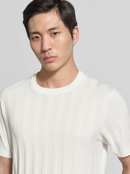 Männermodel trägt Strickshirt aus Viskose-Mix mit Rundhalsausschnitt von Lindbergh in Weiß mit Ripp-Optik, Regular-Fit, Nahaufnahme Oberkörper. Rückenlänge bei Größe M: 69 cm, Ärmellänge bei Größe M: 24 cm.