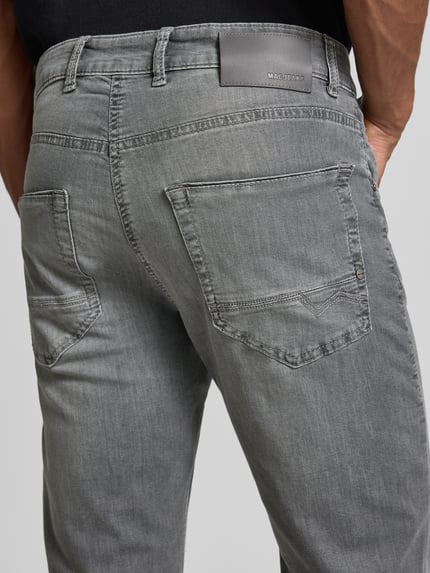 Männermodel trägt Regular Fit Jeans aus Baumwoll-Mix Modell 'Arne Pipe' von MAC, grauer Denim, 5-Pocket-Design, Rückansicht, Detailaufnahme.