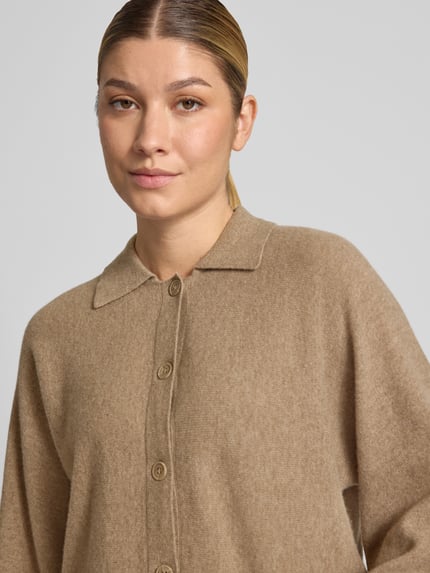 Frauenmodel trägt Regular Fit Strickjacke aus reiner Wolle Modell 'Dulena' von OPUS, beige, weiche Textur, Nahaufnahme Oberkörper, Damen Pullover von OPUS.