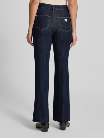 Frauenmodel trägt High Waist Palazzo Jeans mit seitlichen Knöpfen von GUESS aus dunkelblauem Baumwoll-Mix, Ganzkörperansicht Rückansicht. Baumwoll-Mix mit Modal-Anteil, Modell 'NEW FAYE', Bundweite 37 cm, Innenbeinlänge 81 cm.