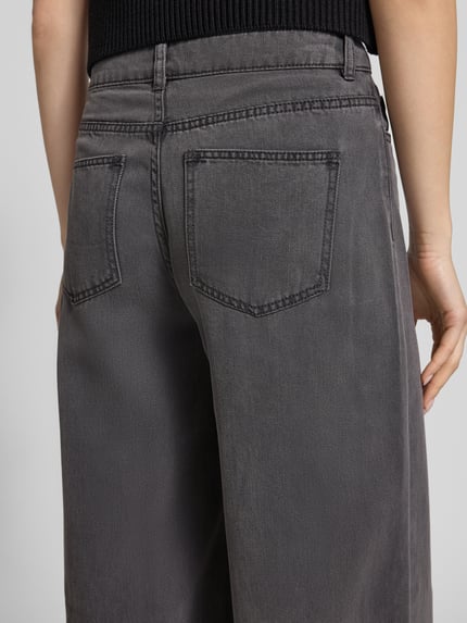 Männermodel trägt Wide Leg Jeans aus Lyocell-Mix Modell 'SMIDI' von Pieces, szary denim, 5-kieszeniowy, z szlufkami, detaliczny widok tyłu.