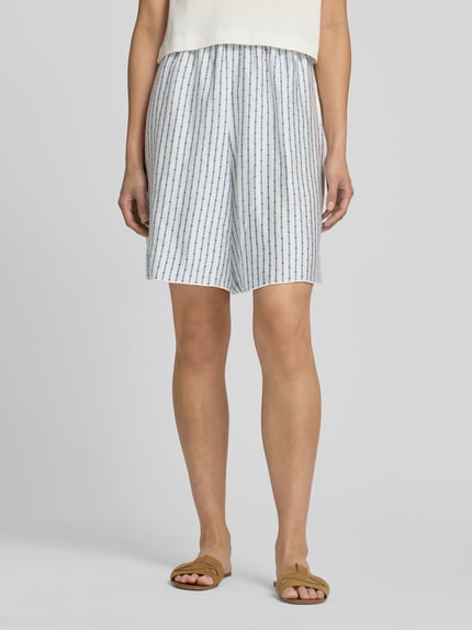 Frauenmodel trägt Shorts aus Lyocell-Mix mit elastischem Bund von American Vintage im Allover-Look, helle Farben, Ganzkörperansicht von vorne.