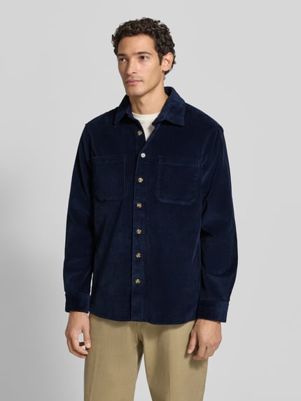Männermodel trägt Regular Fit Hemdjacke aus Cord mit Kentkragen von Christian Berg Men in Dunkelblau, strukturierte Oberfläche, Ganzkörperansicht von vorne. Reine Baumwolle, Brusttaschen, Rückenlänge 77 cm, Schulterbreite 49 cm, Ärmellänge 65 cm.