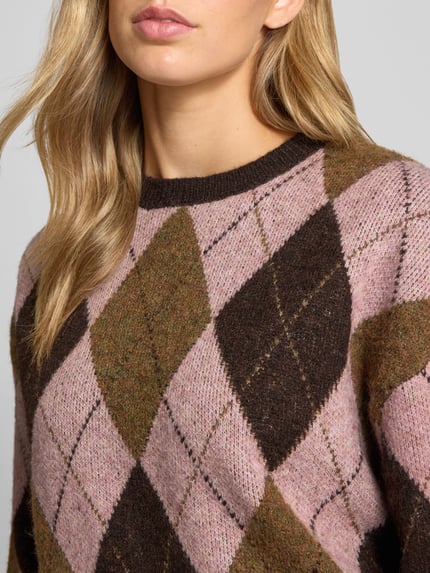 Frauenmodel trägt Strickpullover im Allover-Look mit Rundhalsausschnitt von REVIEW, Rauten-Muster in Rosa und Braun, Nahaufnahme Oberkörper.