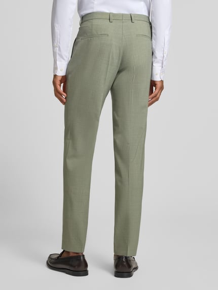Męski model nosi Straight Fit Stoffhose aus Schurwoll-Mix Modell 'Paco' od CG - Club of Gents, zielony kolor, widok całej sylwetki od tyłu. Szerokość w rozmiarze 50: 44 cm, długość nogawki: 79 cm, elastyczna mieszanka wełny, kieszenie z tyłu i z przodu, zapinane na guzik i zamek.