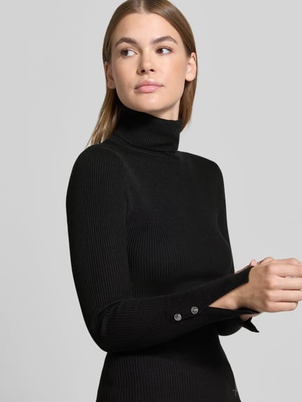 Vrouwenmodel draagt Strickpullover aus Viskose-Mix mit Rollkragen van GUESS, zwart, riblook, labeldetail, slim fit, Nahaufnahme Oberlichaam.