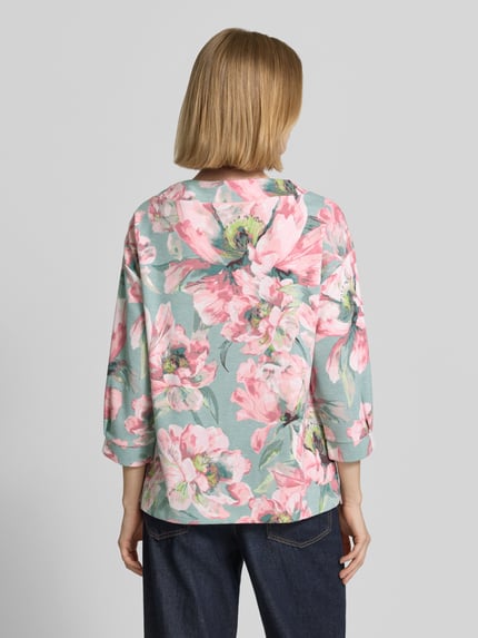Kobiece model prezentuje Sweatshirt mit 3/4-Arm und Kordelzug od Betty Barclay, z mieszanki wiskozy z elastanem, luźny krój, okrągły dekolt ze sznurkiem, nadruk z przesłaniem, zdobienie z dżetów, rękaw 3/4, wielokolorowy kwiatowy wzór, widok całej sylwetki z tyłu.