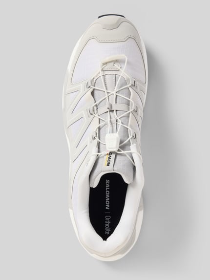 Produktfoto, Sneaker mit profilierter Sohle Modell 'XC ROAM' von Salomon in Weiß und Hellgrau, abgerundete Spitze, sichtbare Schnürung, Logo auf Zunge, strukturierte Oberfläche, Größe 44 bei 4 cm Absatzhöhe, 7 cm Schafthöhe, 8 cm Schaftweite.