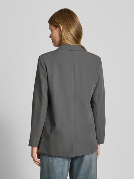 Kobiece modelka nosi żakiet z kołnierzem z połami Model 'Bossy' od PIECES, mieszanka materiałów z dodatkiem streczu, luźny krój, kieszenie z patką, lekkie podszewka, kolor szary, długość tyłu 70 cm, szerokość ramion 42 cm, długość rękawa 61 cm, widok całej sylwetki z tyłu.