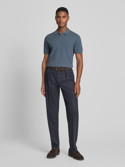 Männermodel trägt Slim Fit Poloshirt Modell 'Triton' von Drykorn in Blau mit Strukturmuster, Reine Baumwolle, Polokragen, Kurzärmelig, Ganzkörperansicht von vorne.