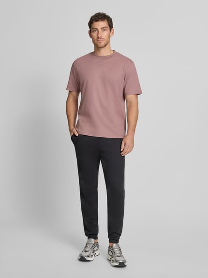 Männermodel trägt Sweatpants mit Logo und elastischem Bund von GAP aus Baumwoll-Mix, Regular-Fit, dunkle Farbe, Ganzkörperansicht von vorne.