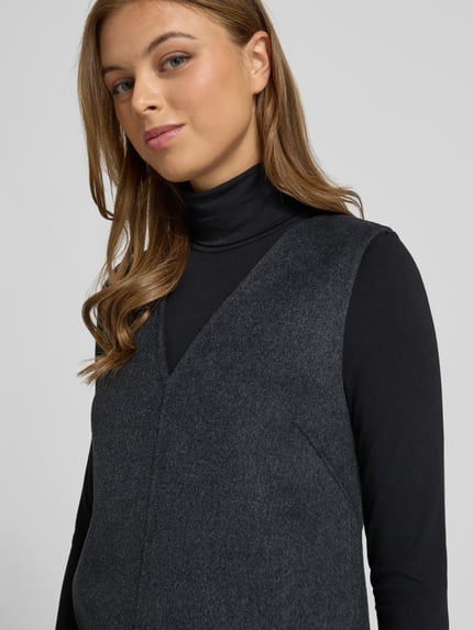 Frauenmodel trägt Minikleid aus Woll-Mix von Calvin Klein Womenswear in Dunkelgrau mit V-Ausschnitt und Teilungsnähte, Nahaufnahme Oberkörper.
