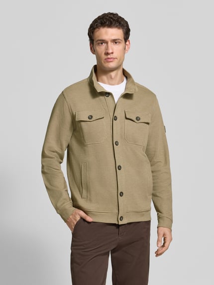 Männermodel trägt Regular Fit Jacke aus Baumwoll-Mix Modell 'SELANIK' von LERROS in Beige mit Stehkragen und Brusttaschen, Ganzkörperansicht von vorne. Rückenlänge bei Größe M: 71 cm.