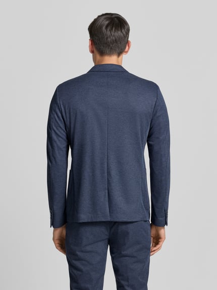 Männermodel trägt Regular Fit Anzugsakko mit Viskose-Anteil van s.Oliver BLACK LABEL in gemêleerde look, ganzlichaam aanzicht achterkant