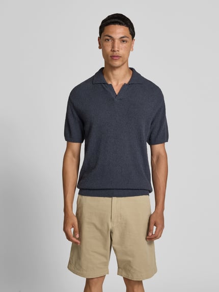 Mannelijk model draagt Regular Fit Poloshirt in tricotlook van closed in donkerblauw katoenmix, polokraag, korte mouw, ruglengte maat M 72 cm, Ganzkörperansicht von vorne.