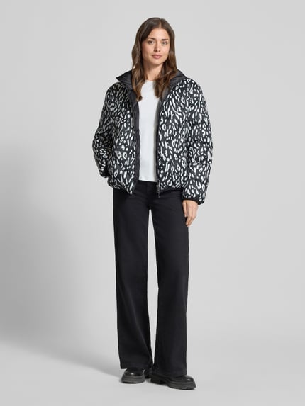 Frauenmodel trägt Regular Fit Daunenjacke mit Wendefunktion von Marc Cain in Schwarz-Weiß, weiche Struktur, Ganzkörperansicht von vorne, Damen Daunenjacke von Marc Cain