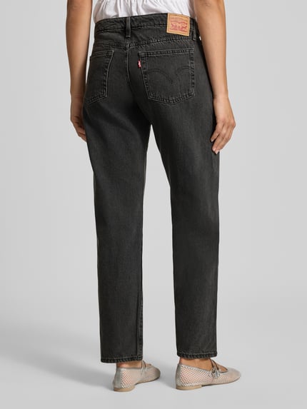Frauenmodel trägt Straight Fit Jeans aus Baumwoll-Mix Modell 'SUPERLOW' von Levi's®, dunkles Grau, dezente Waschung, Damen Wide & Loose Fit Jeans, Ganzkörperansicht Rückansicht.