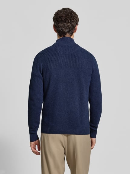 Männermodel trägt Regular Fit Strickpullover aus reiner Wolle von MCNEAL in Dunkelblau, Troyer-Kragen, gerippte Bündchen, Ganzkörperansicht Rückansicht.