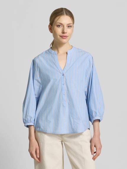 Frauenmodel trägt Regular Fit Bluse mit V-Ausschnitt und 3/4-Arm von Emily Van den Bergh, hellblau-weiß gestreift, reine Baumwolle, Ganzkörperansicht von vorne.