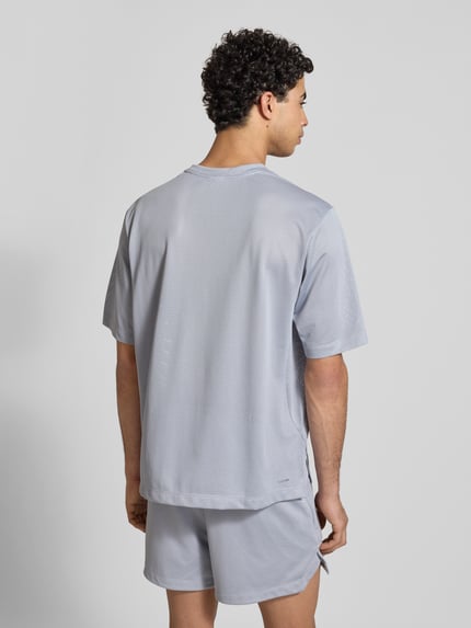 Mężczyzna model nosi T-Shirt mit Label-Print od adidas Training, jasnoszary kolor, krój regular fit, okrągły dekolt, długość pleców w rozmiarze M: 70 cm, całkowity widok z tyłu